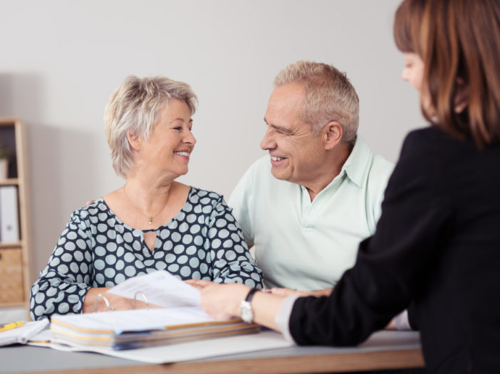 Happy Senior Couple Talking to a Female Agent About downsizing home